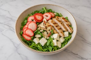 Ensalada de pollo grillado, rúcula, frutillas, nueces y queso