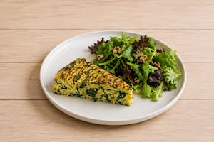 Tortilla de vegetales con ensalada de hojas verdes y nueces