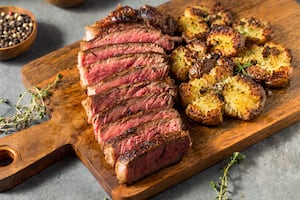 Bife de chorizo con papas aplastadas y chimichurri