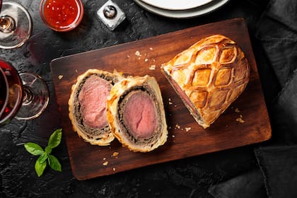 Beef Wellington - beef tenderloin festive dish. English cuisine. Black stone background. top view