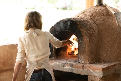 Hermine cocinando en el horno de barro de La Fe.