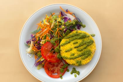 Medallones de mijo y calabaza con aderezo de hojas verdes y ensalada fresca