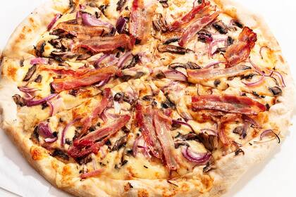 Pizza de estilo neoyorkino con mozzarella, portobellos, cebolla y panceta